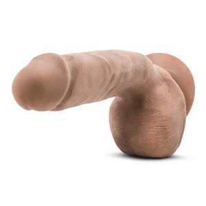 Realistic flesh-colored dildo with testicles and suction base on white background