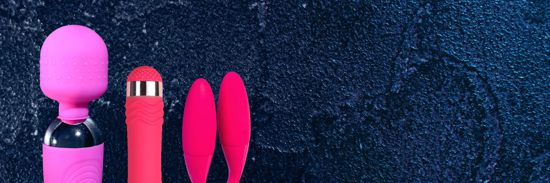 Four pink and red massage tools on a dark textured background