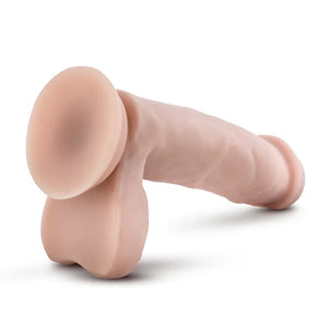 Realistic flesh-colored dildo with suction base on white background