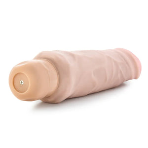 9-inch natural-colored vibrating dildo with textured shaft and beige battery compartment on white background