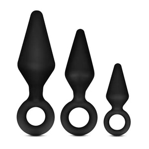 Set of three black silicone anal plugs with tapered shapes and finger ring bases on white background