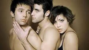 Three young adults in close embrace against a brown backdrop, highlighting diverse relationships
