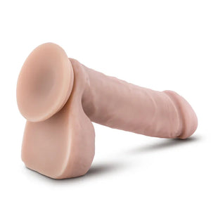 Realistic flesh-tone suction cup dildo with detailed shaft and testicles on white background