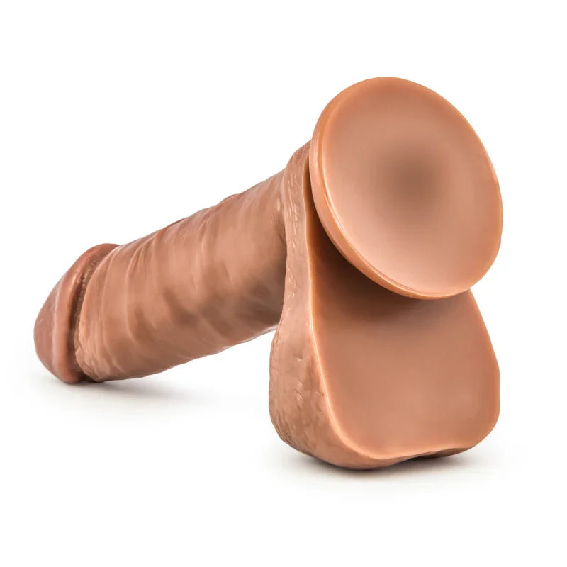 Realistic brown dildo with attached suction cup base on white background