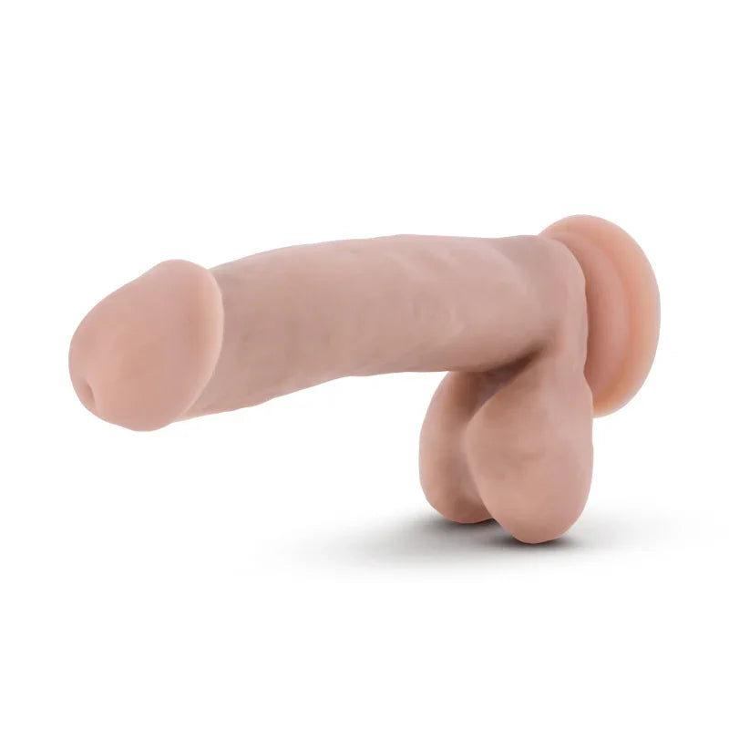 Realistic flesh-toned dildo with testicles and suction base on white background, adult novelty toy
