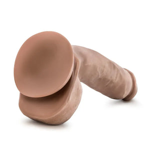 Realistic flesh-tone male dildo with suction base on white background
