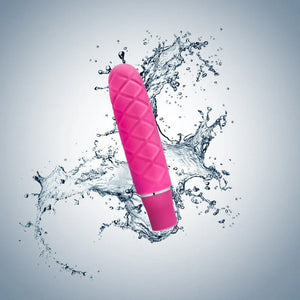 Pink Luxe Cozi Mini vibrator with quilted texture against a splash of water background